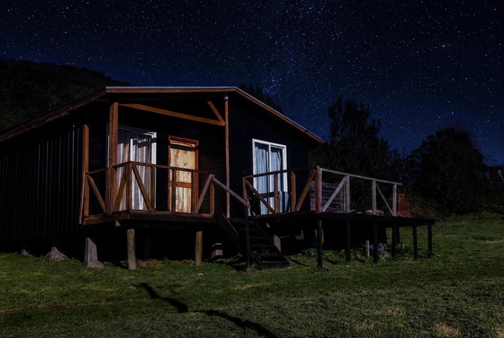 a cabin in a field at night with a starry sky at Cabaña lomas de chaica in Puerto Montt