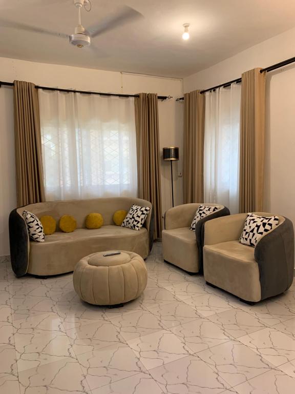 a living room with two couches and a table at Iconic lux living in Malindi