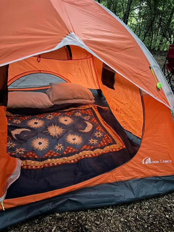 an orange tent with a bed in it at Tente en jardin in Boulazac