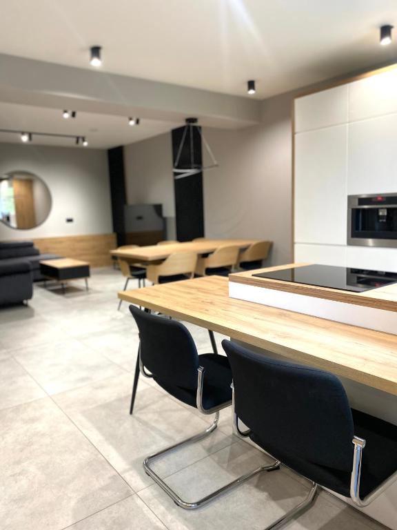 a large room with tables and chairs and a kitchen at Platinum Apartment in Wałbrzych
