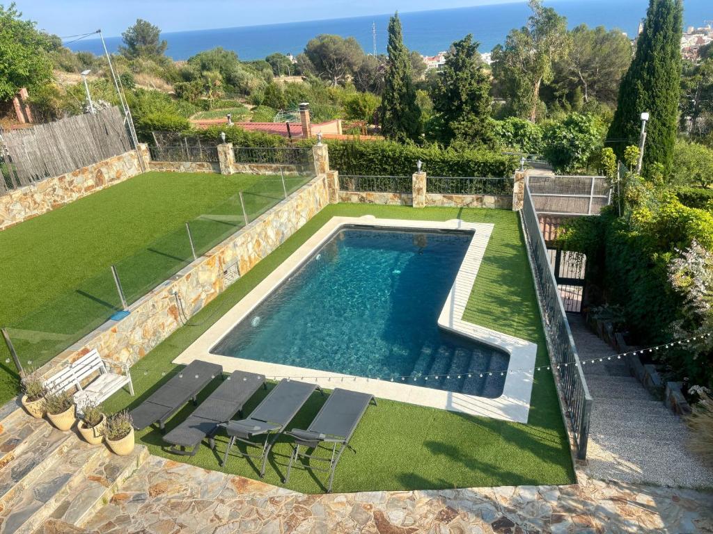 an image of a swimming pool with chairs and a lawn at Villa Mar in Teià