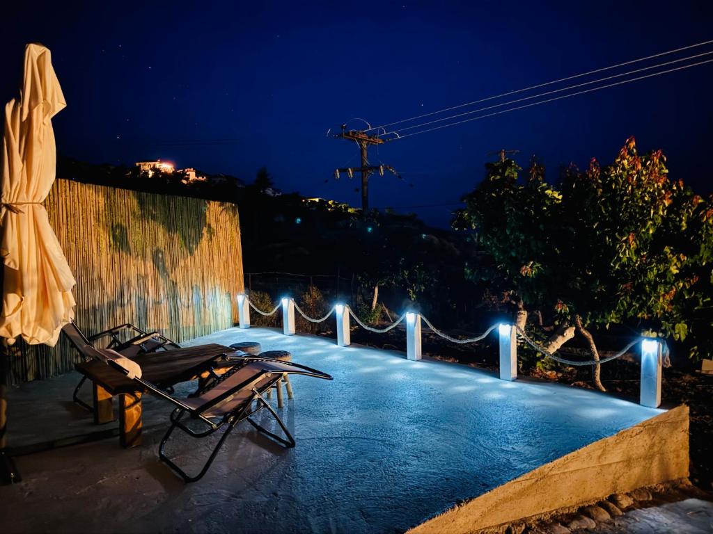 a patio with chairs and lights at night at Faidrahouse in Alyki