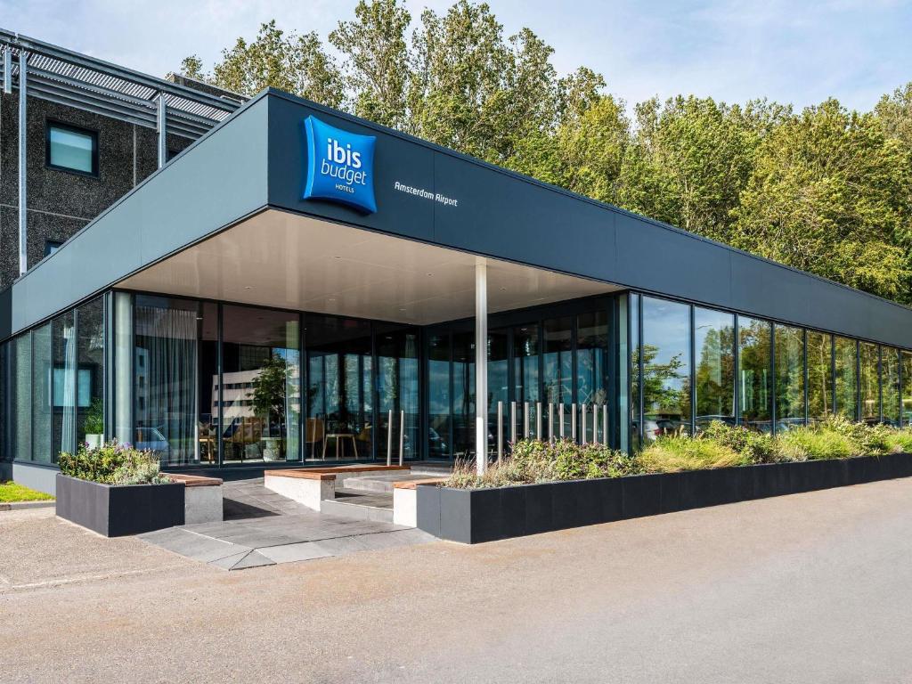 an office building with a blue sign on it at ibis budget Amsterdam Airport in Badhoevedorp