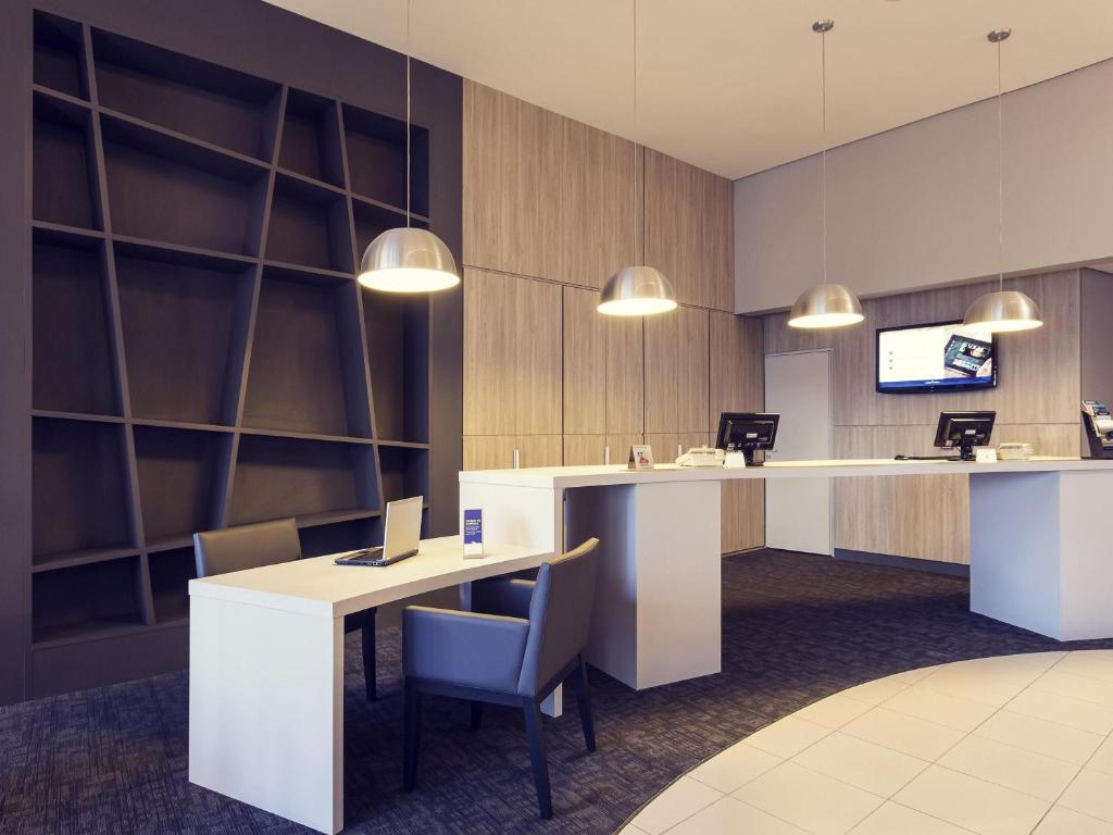 an office with a desk with a laptop on it at Mercure Sao Jose dos Campos in São José dos Campos