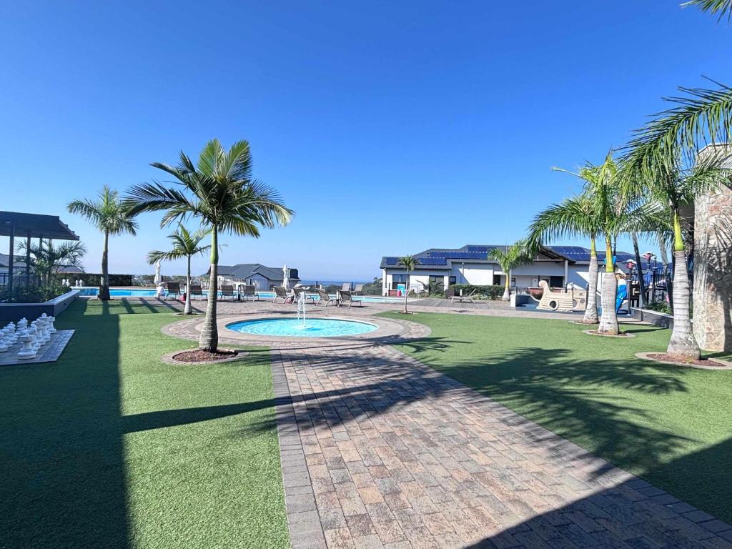 a park with palm trees and a swimming pool at Ocean's Edge Escape! in Ballito