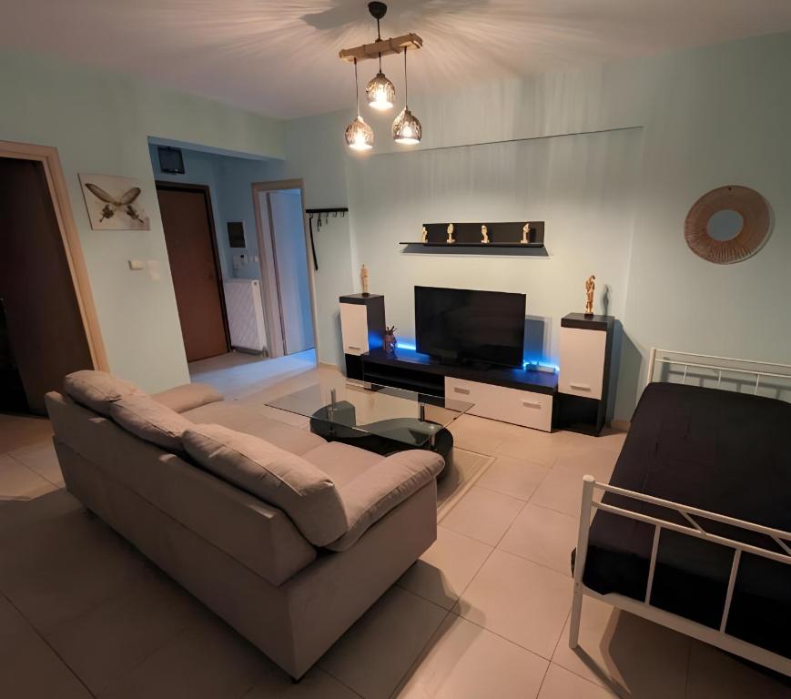 a living room with a couch and a flat screen tv at Relaxing home 80m from the sea in Perea