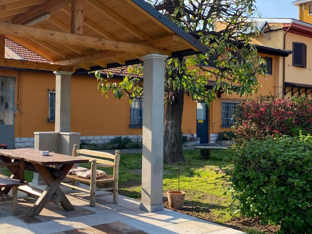 a picnic table and bench under a wooden pergola at La Magnolia in Magenta