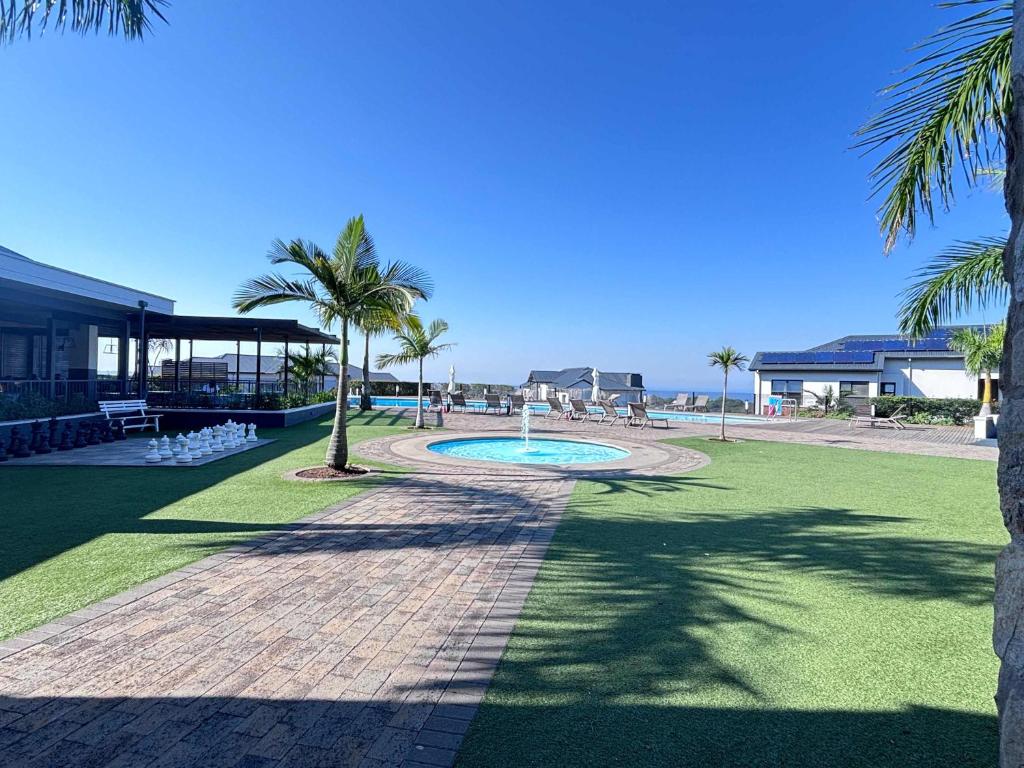 a park with a swimming pool and palm trees at Ocean Sunrise! in Ballito