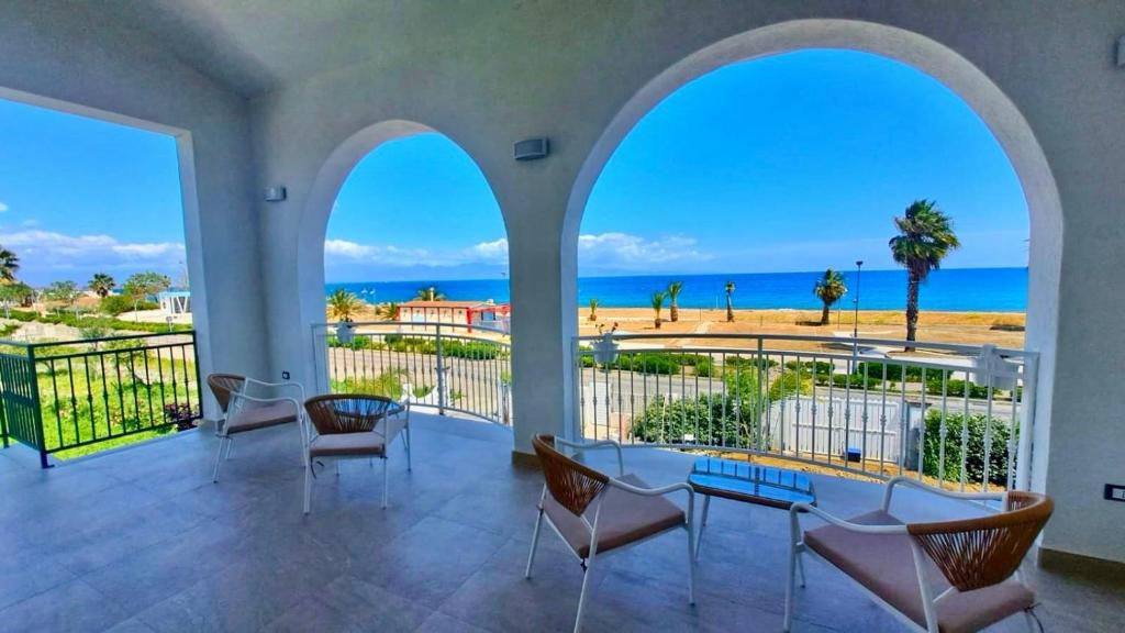 a large room with a balcony with a view of the ocean at VillaVenere in Rossano