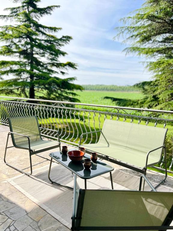 a patio with two chairs and a table with bowls on it at Maison familiale champêtre 8 pers in Fontet