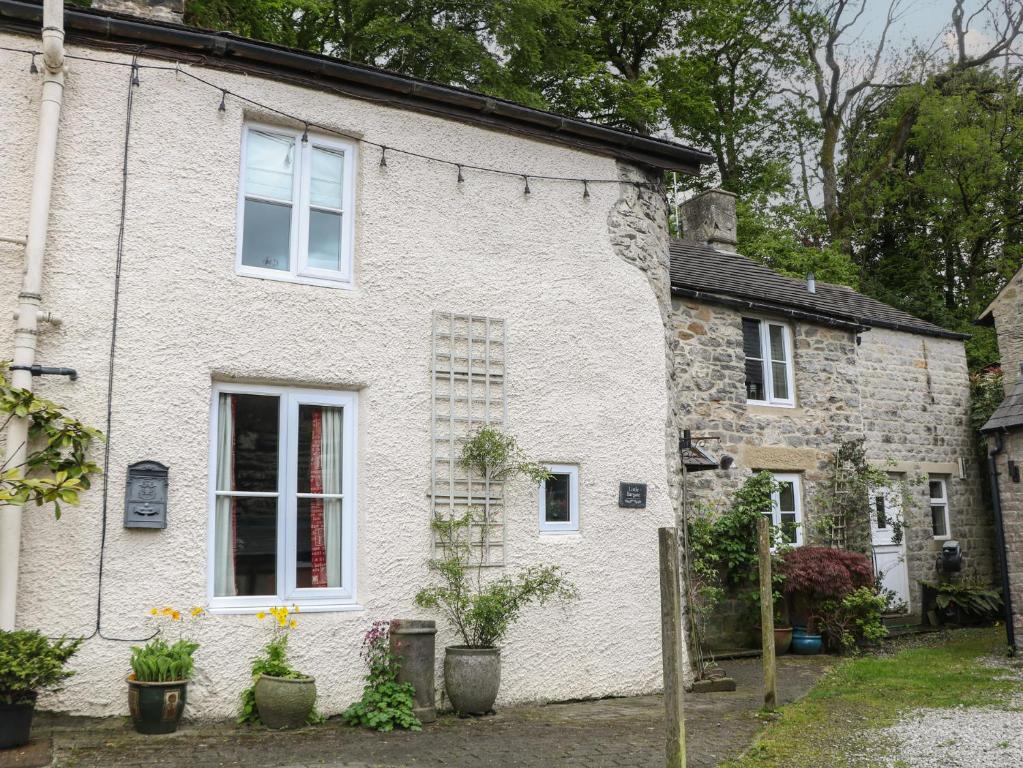 a white brick house with plants in front of it at Little Bargate in Castleton