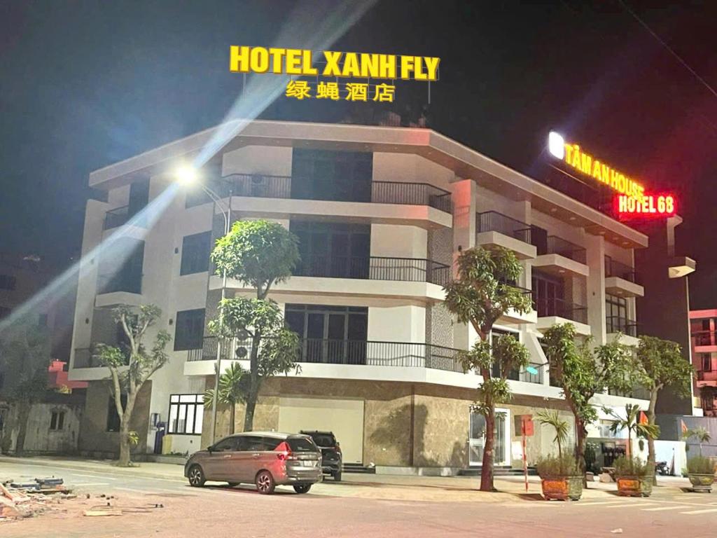 a hotel kammiry building with a car parked in front at Hotel Xanh Fly in Nhật Tựu