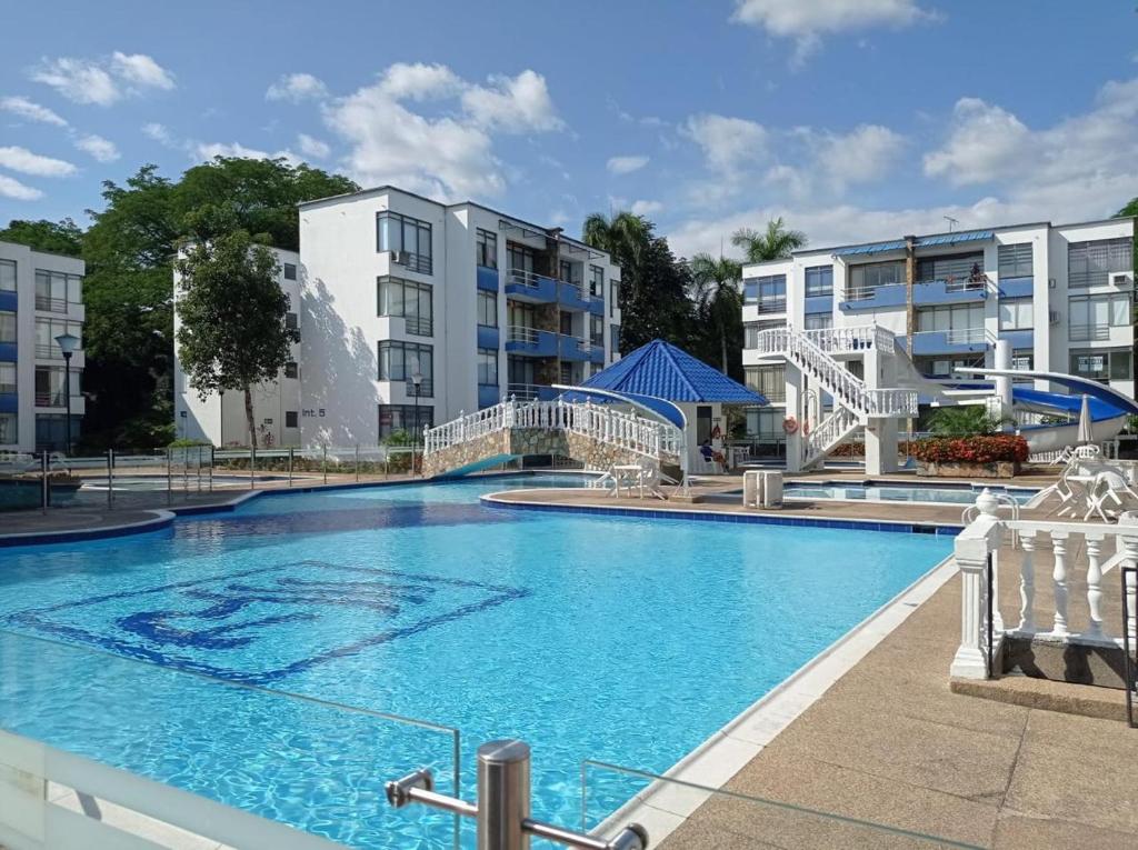 a swimming pool in front of some apartment buildings at APTO CENTRO DE MELGAR CON PISCINA EN CONJUNTo in Melgar
