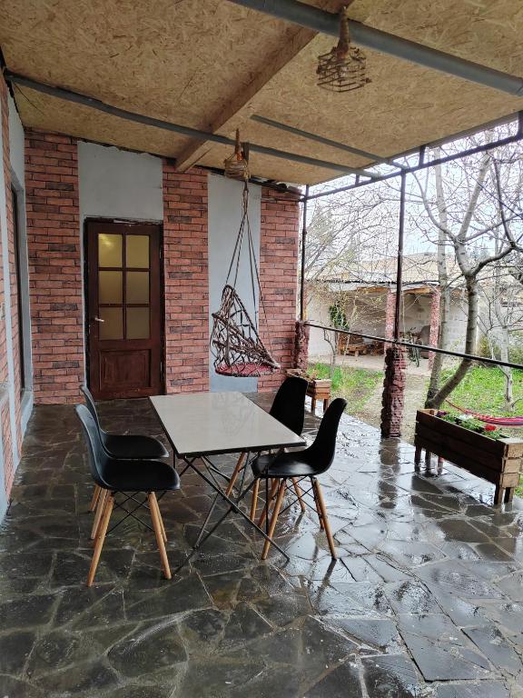a patio with a table and chairs on a stone floor at STEPANAVAN guesthouse in Stepʼanavan
