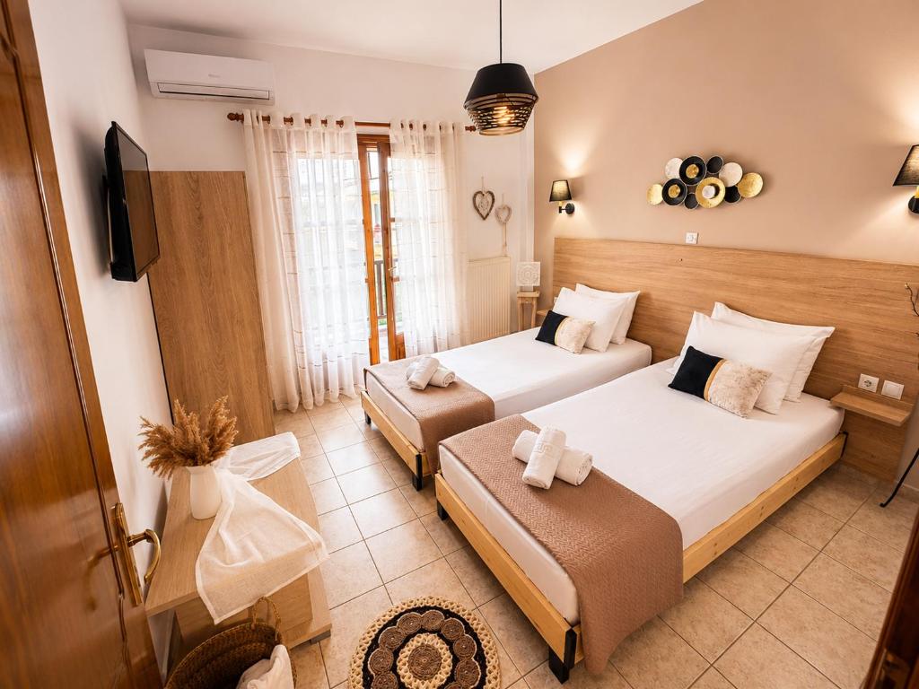 a hotel room with two beds and a television at Villa Evgenia(Leonidas) in Ierissos