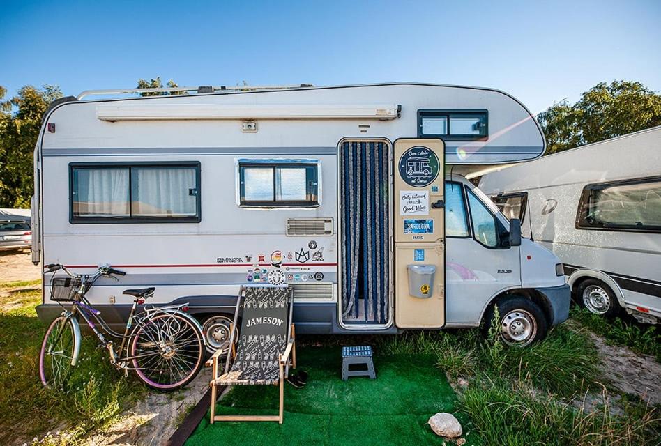 a white caravan with a bike parked next to it at Maszoperia Sun4Hel Działka kamperowa in Jastarnia