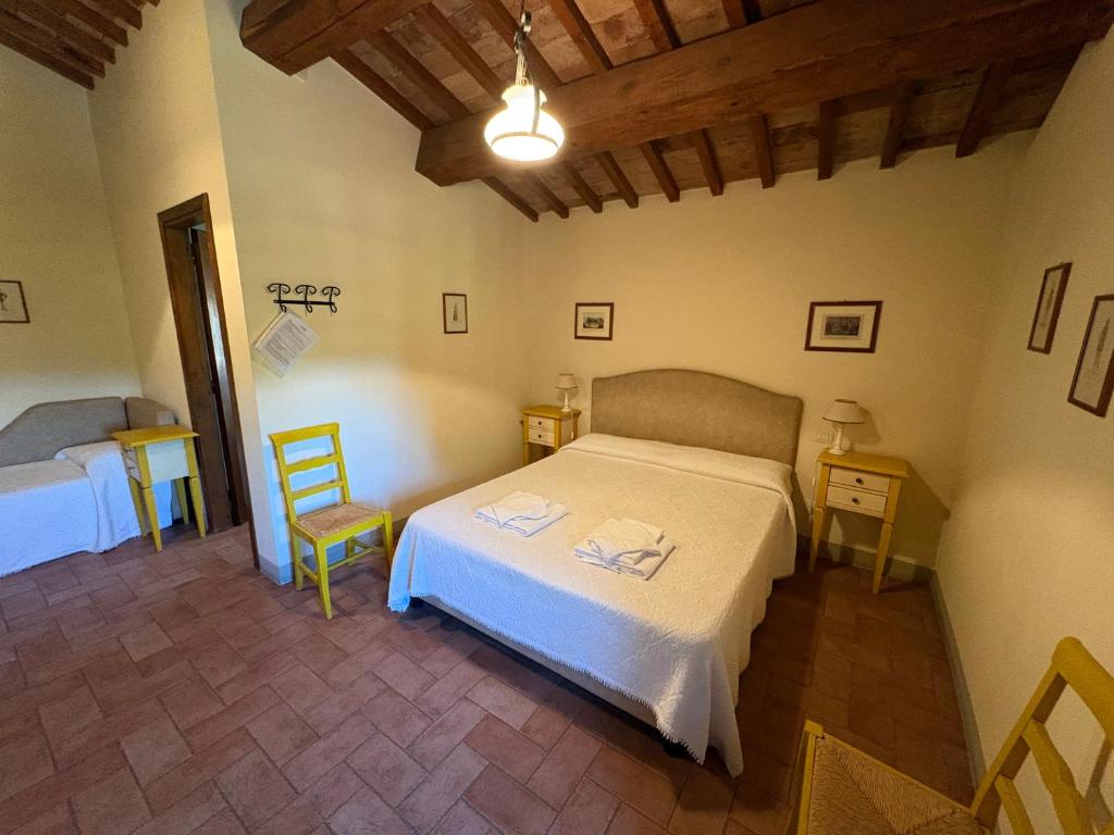a bedroom with a bed and two tables and a chair at Molenda B&B in Città di Castello