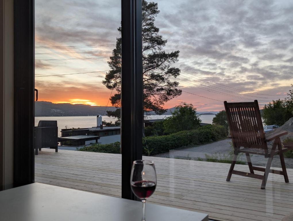a glass of wine sitting on a table in front of a window at Oslofjord Sea View in Hvitsten