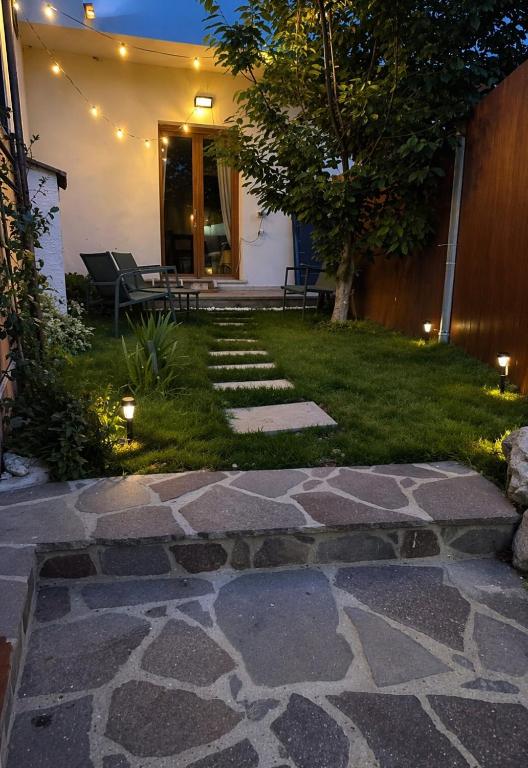 a backyard with a stone walkway and a patio with lights at Su Entu Suite Free Parking 5 min from the sea in Giba