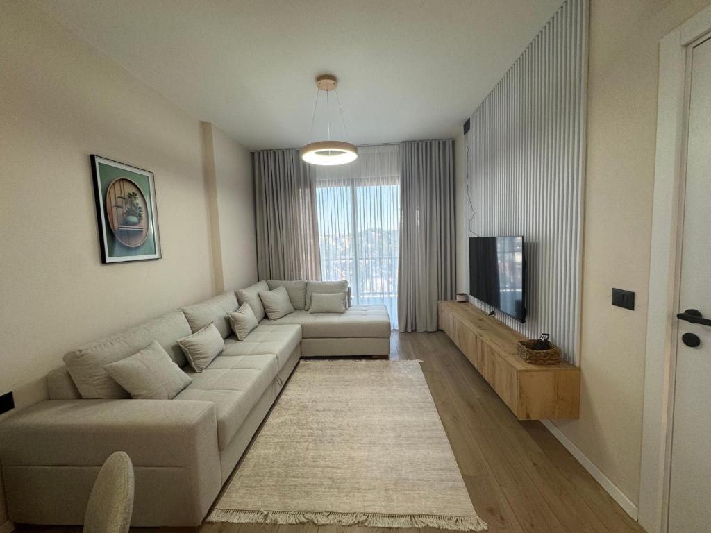 a living room with a couch and a tv at Dio East Apartments in Tirana