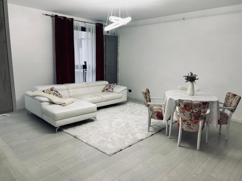 a living room with a white couch and a table at Hij Apartaments in Rădăuţi