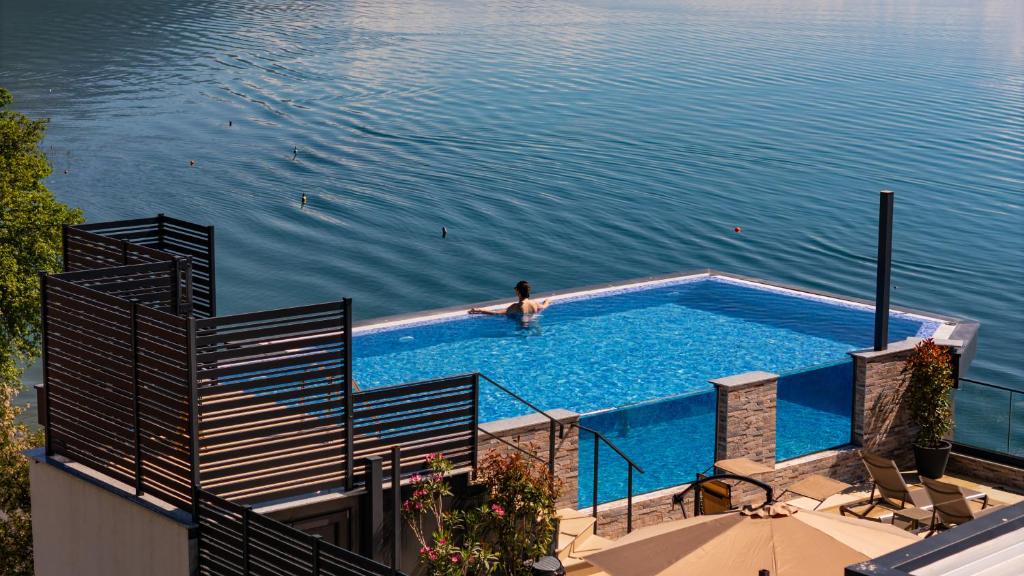 a person swimming in a swimming pool in the water at Boutique Hotel Nika in Ohrid