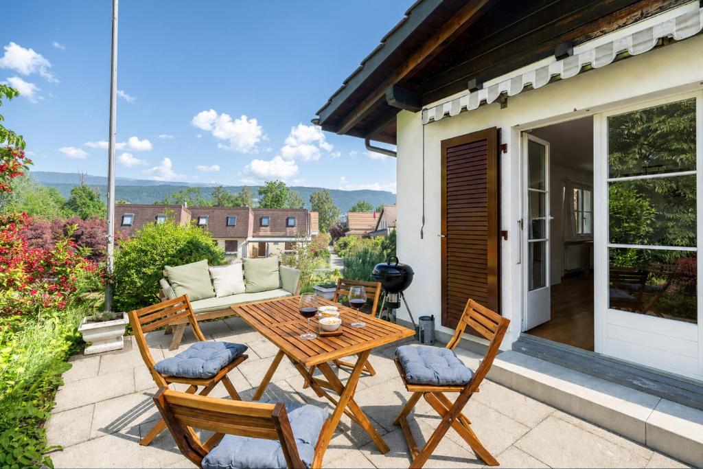 a patio with a table and chairs and a couch at Trois Lacs Suites in Erlach