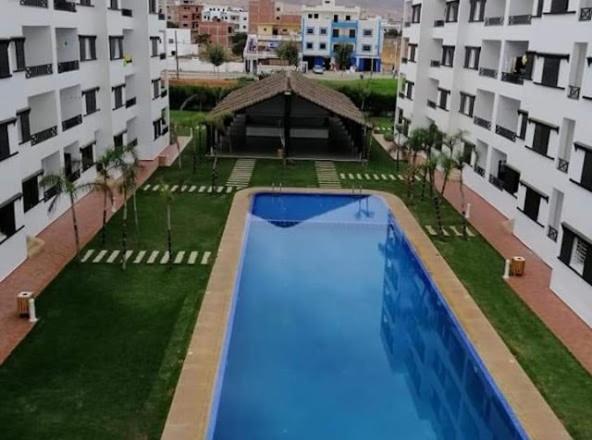 an overhead view of a swimming pool in the middle of a building at Chic apartment with secure pool in Oued Laou