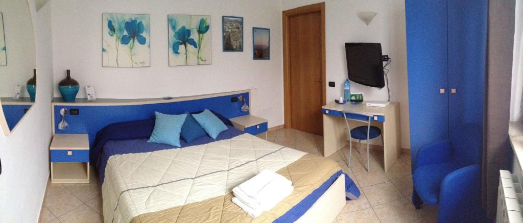 niebiesko-biała sypialnia z łóżkiem i telewizorem w obiekcie B&B Villa Giglio w mieście Catanzaro