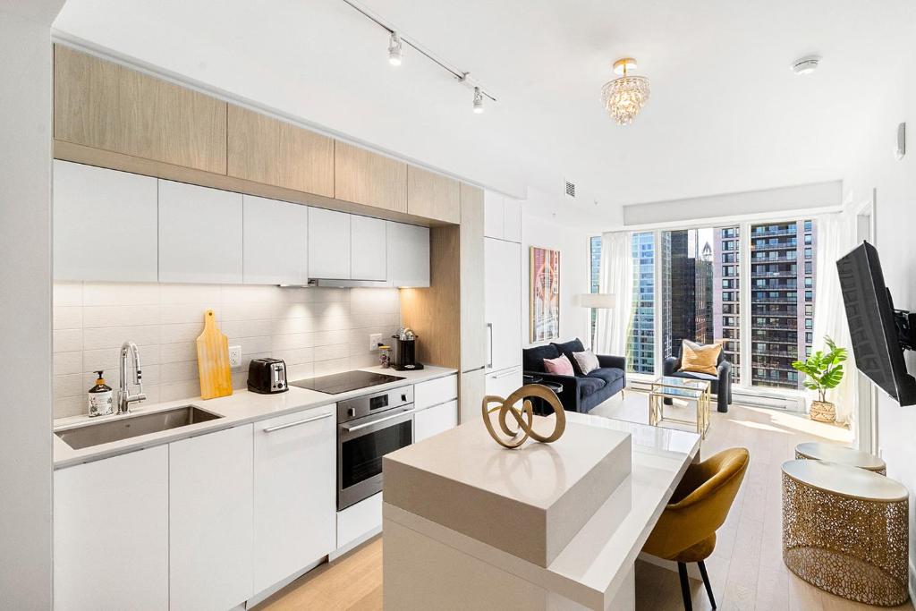 a kitchen with white cabinets and a large window at Luxury Apartments with View & Indoor Heated Pool in Montreal