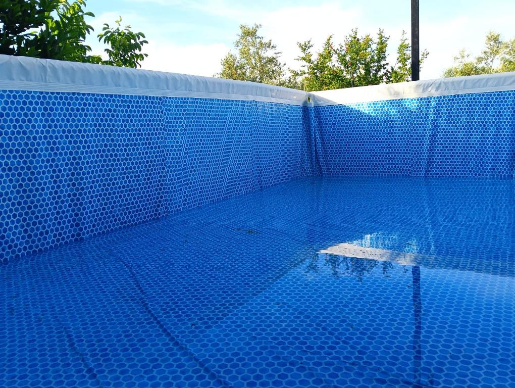 a blue swimming pool with a blue tile wall at Casita del Romero Ronda in Ronda