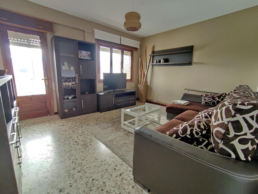 a living room with a couch and a television at Torre Plaza 5 in Boiro