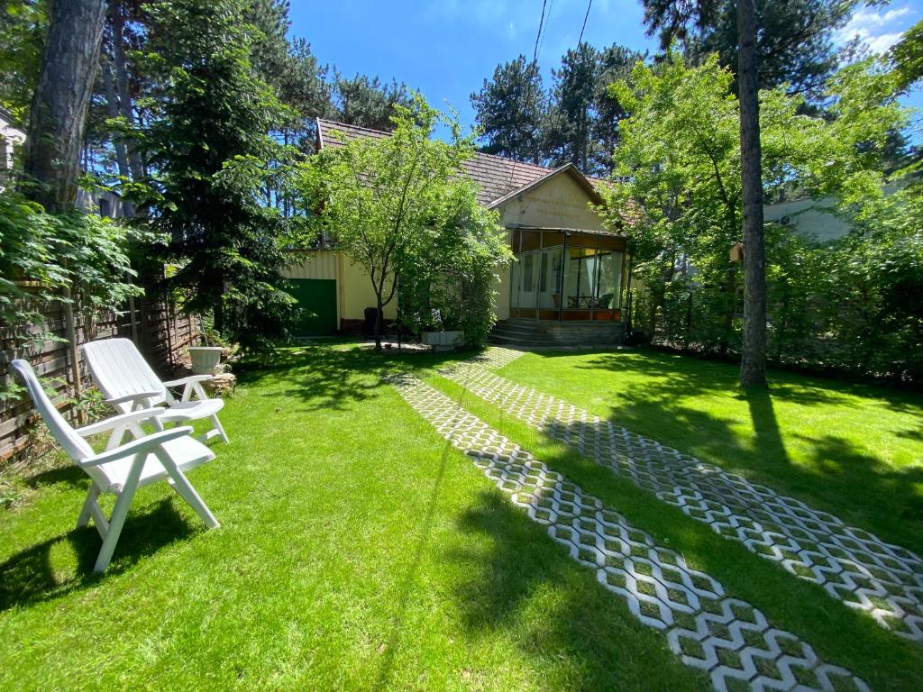 a yard with a white bench and a house at Arany Toboz Vendégház in Siófok