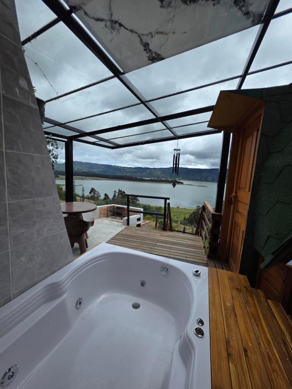 a bath tub in a room with a view of the water at Benigno Mirador in Guatavita