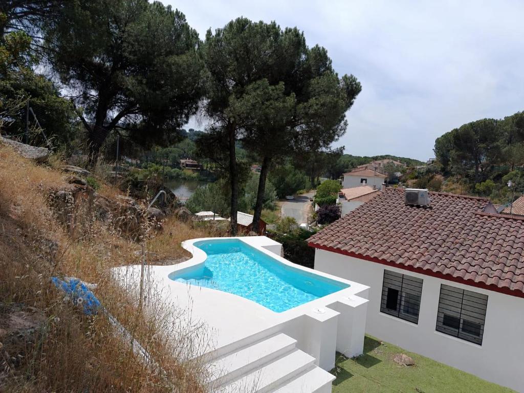 a villa with a swimming pool next to a house at La Senda del Lago PISCINA PRIVADA in Córdoba