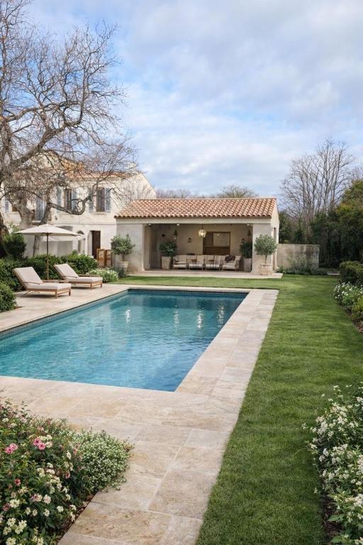 a swimming pool in the yard of a house at Domaine de la batelle in Arles