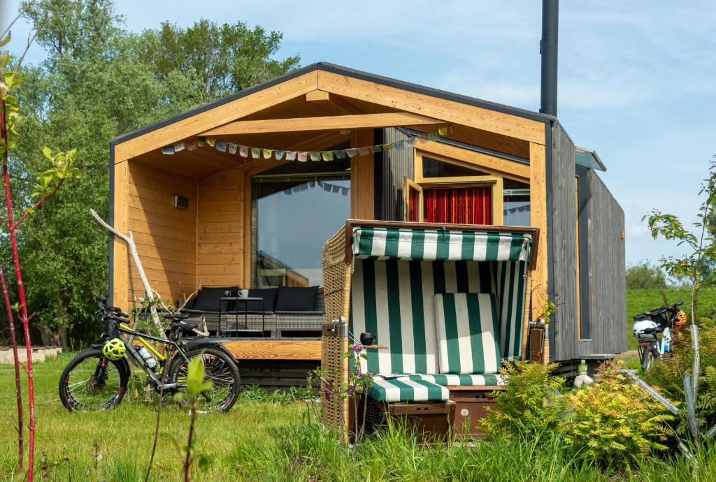 a small house with a bike in the grass at 408 Kleini-Haus mit Kamin und Strandkorb in Bleckede
