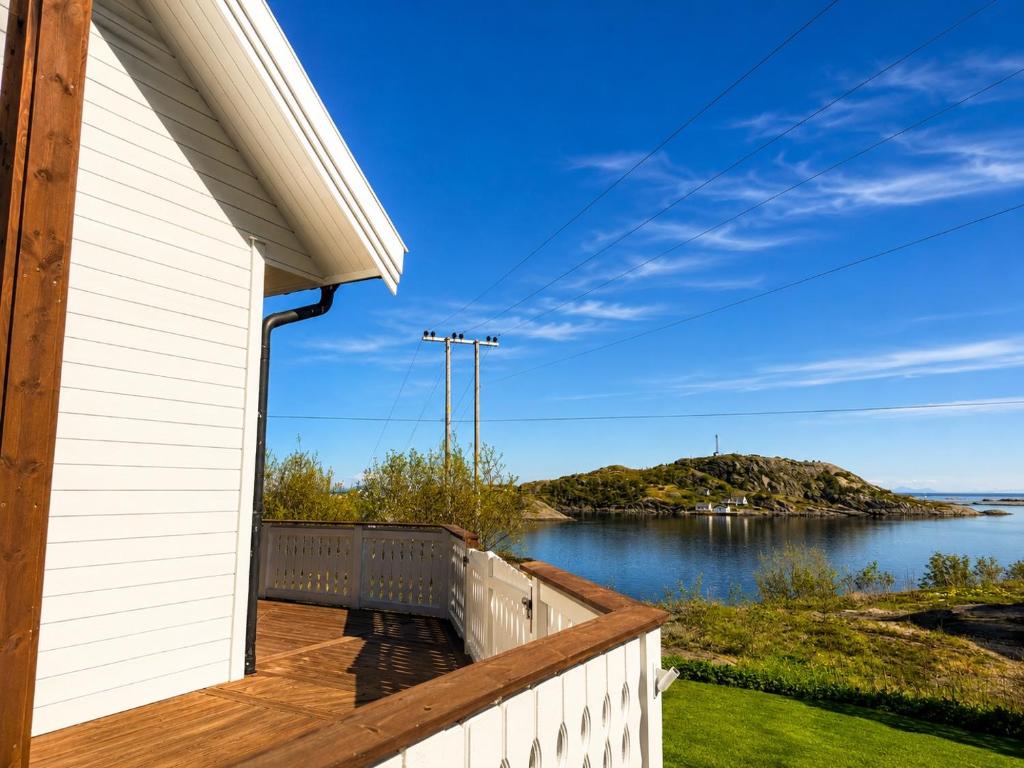 a house with a balcony with a view of the water at Myranhuset - Amazing View in Moskenes