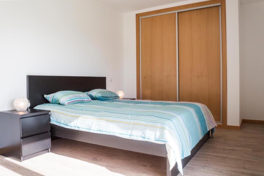 サン・マルティーニョ・ド・ポルトにあるCarmonaのベッドルーム1室(ベッド1台、木製クローゼット付)