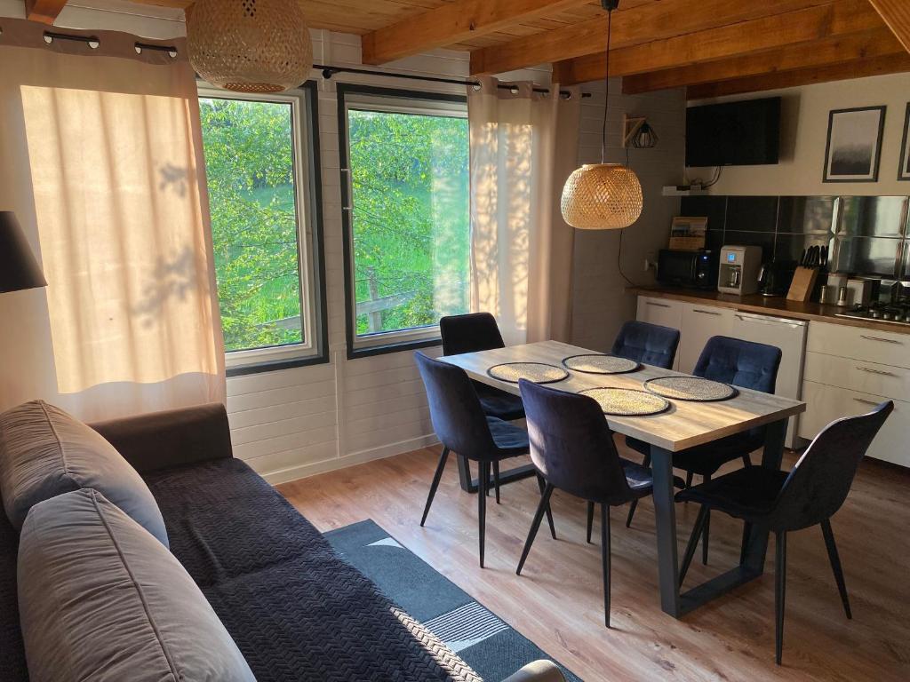 a living room with a table and chairs and a couch at Domki że Hej Bieszczady in Ustrzyki Dolne