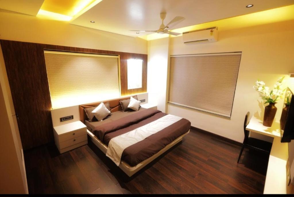 a bedroom with a bed and a window and a desk at Velora Stays - Nr Airport & World trade center in Pune