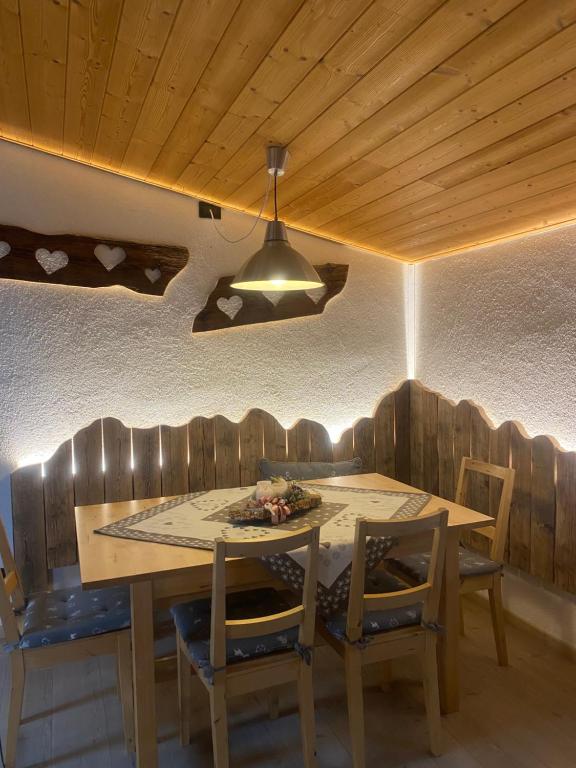 a dining room with a wooden table and chairs at Mansarda Ossana in Fucine