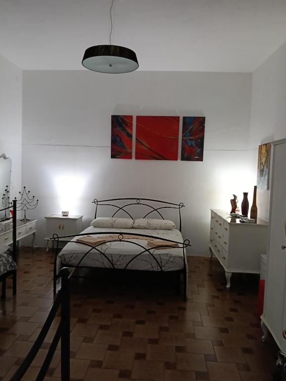 a bedroom with a bed and a painting on the wall at Simbilis B&B Holiday Experience Mimose in Quartu SantʼElena