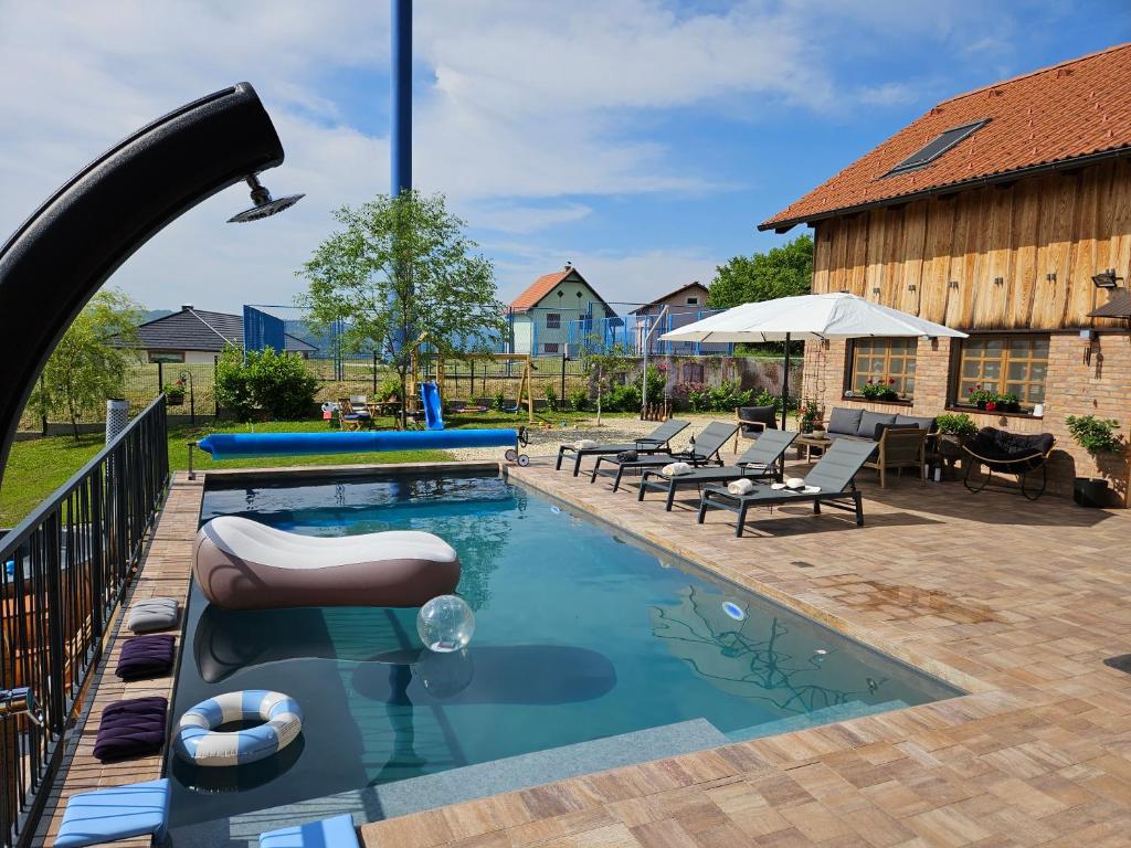 a swimming pool with lounge chairs and a water slide at Vila RAMI in Donja Poljana