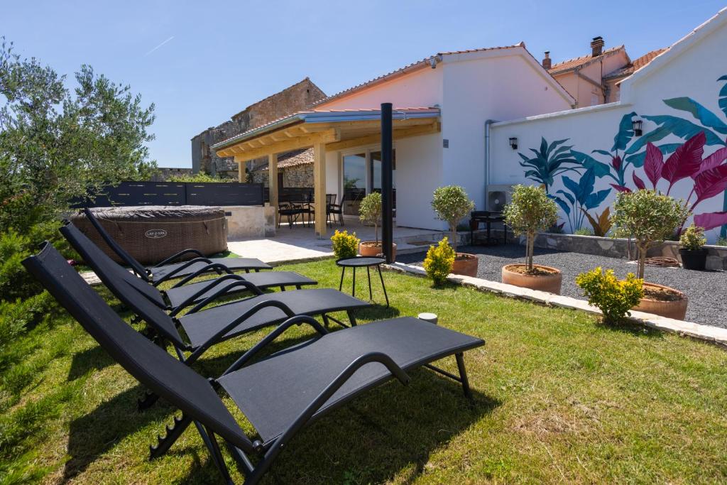 a group of lawn chairs sitting in the grass at Villa Romana in Bibinje