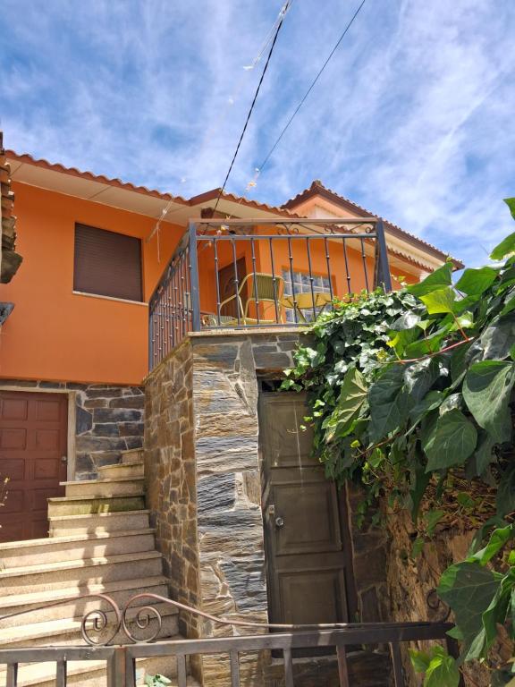 a house with a balcony on top of it at Casa dos Ramos in Rio de Fornos