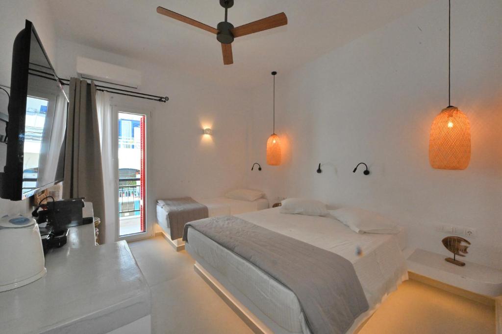 a bedroom with a bed and a ceiling fan at kleris apartment 3 in Tinos