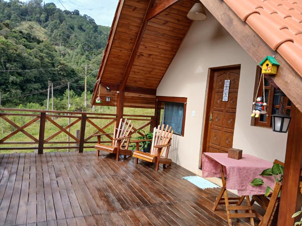 a porch of a house with a table and chairs at Chalé 2 com hidromassagem in Camanducaia
