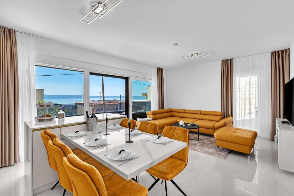 a dining room and living room with a table and chairs at Apartman A Villa Legato in Tučepi