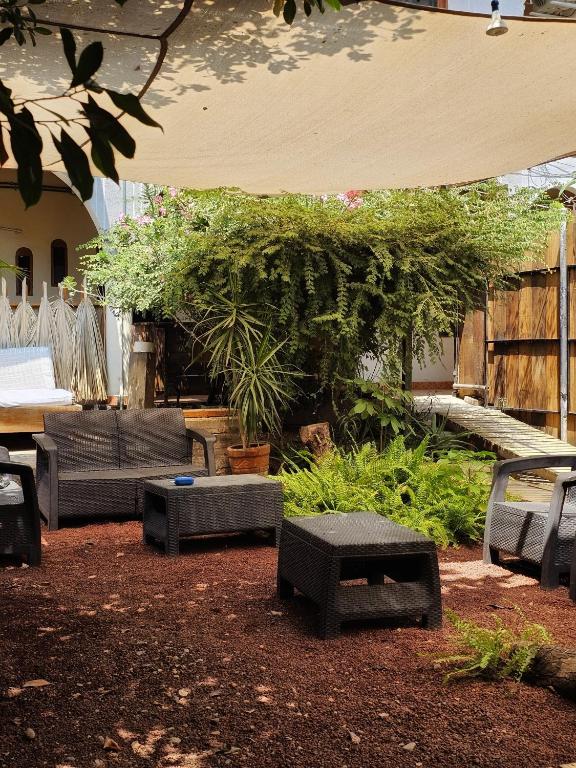 a patio with chairs and tables and a large umbrella at Casa Kal'i in Brisas de Zicatela